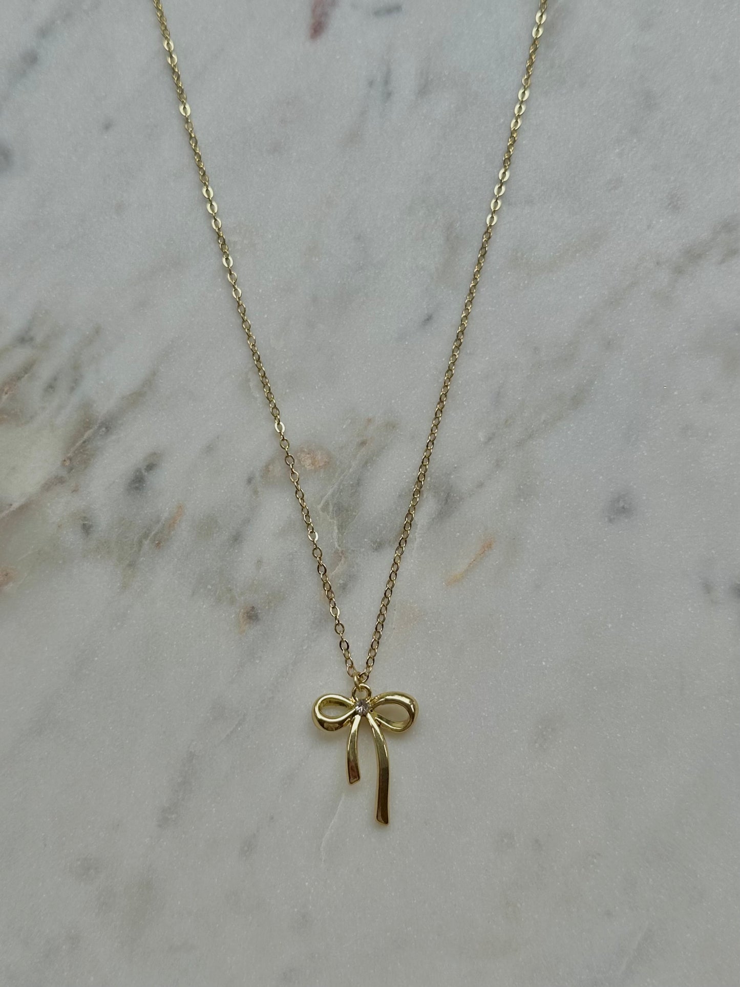 gold bow with gem necklace